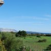 Paesaggio collinare con vista sul mare e montagna.