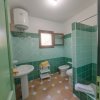 Bagno verde con doccia, lavabo e bidet.