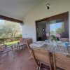 Patio con tavolo in legno e sedie, vista giardino.