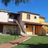 Casa a due piani con balconi, giardino frontale.