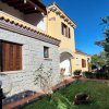 Casa con pareti in pietra e giardino curato.