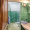 Bagno con piastrelle verdi e doccia.