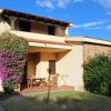 Casa con terrazzo e fiori viola rampicanti.