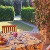 Tavolo da giardino apparecchiato con tazze e frutta.