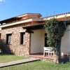 Casa in pietra con piccolo portico e giardino.