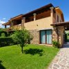 Villa a due piani con giardino e vialetto in pietra.