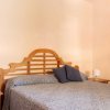 Camera da letto con letto matrimoniale, testiera in legno e specchio a parete.