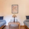 Una stanza con due letti singoli, un tavolino al centro, lampada, e un quadro appeso sopra.