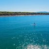 Persona su paddle board in mare luminoso.