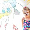 Bambina con viso truccato da felino accanto a un grande disegno di uccello colorato.