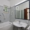 Bagno con vasca, specchio e lavabo.