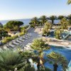 Terrazza con piscine, lettini e vista mare.