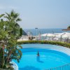 Piscina circolare con vista su mare e terrazza.