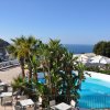 Vista mare con piscina e palme.