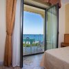 Porta finestra aperta su un balcone con vista mare.