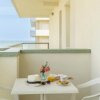 Balcone con tavolo, sedie e colazione al mare.