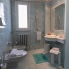 Bagno con lavabo, bidet, finestra e asciugamani bianchi e blu.