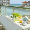 Terrazza con tavolo apparecchiato, sedie bianche e vista mare.