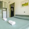 Letto matrimoniale con asciugamani arrotolati, vicino a una cucina.