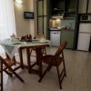 Cucina con tavolo rotondo, sedie di legno e mobili verdi.