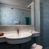 Bagno moderno con lavabo sospeso, specchio ampio e doccia angolare a piastrelle azzurre.