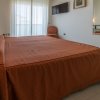 Stanza da letto con letto matrimoniale, TV a parete e sedia accanto a una grande finestra.