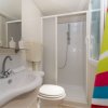 Bagno moderno con doccia, lavandino e asciugamano colorato.