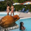 Piscina con statue e sdraio blu.