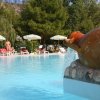 Piscina con anfora e ombrelloni colorati.