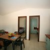 Sala da pranzo con tavolo, sedie e due porte aperte.