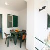 Veranda coperta con tavolo e ingresso cucina.