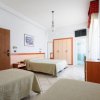 Camera d'albergo con tre letti singoli.