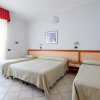 Camera d'albergo con tre letti, due singoli e uno matrimoniale.