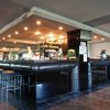 Moderno bar con bancone nero illuminato.