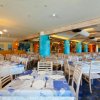 Ristorante ampio con tavoli apparecchiati e colonne colorate.