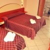 Camera d'albergo con due letti matrimoniali.