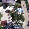 Vista aerea di un giardino con piscina e ombrelloni.