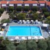 Vista aerea di un complesso con piscina e ombrelloni.