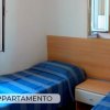 Due letti singoli con copriletti blu in una stanza luminosa.