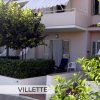 Villetta con terrazza, siepi e alberi.