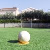 Campo da calcetto con palla e rete sullo sfondo.