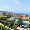 Vista panoramica su villaggio con piscina e mare.