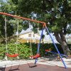 Altalene in un parco giochi alberato.