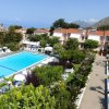 Vista dall'alto di una piscina circondata da giardini e edifici.