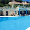 Piscina azzurra con terrazza e sedie a sdraio.