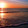 Tramonto sull'oceano con riflessi sull'acqua.