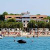 Hotel fronte mare con persone che nuotano.