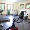 Piccola palestra con attrezzi e finestre verdi.