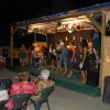 Persone su un palco all'aperto, pubblico seduto.