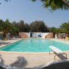 Piscina all'aperto con palme e lettini.